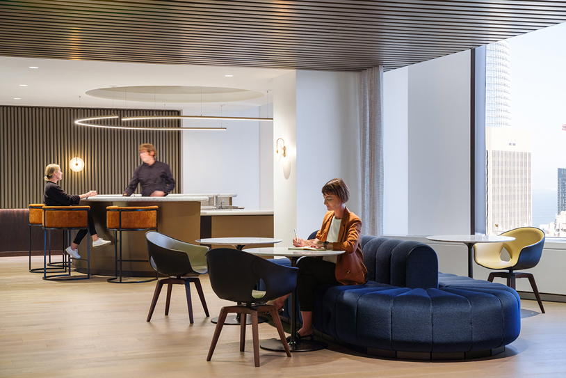 Kirkland & Ellis' contemporary office space with individuals seated at tables, engaged in work and collaboration.