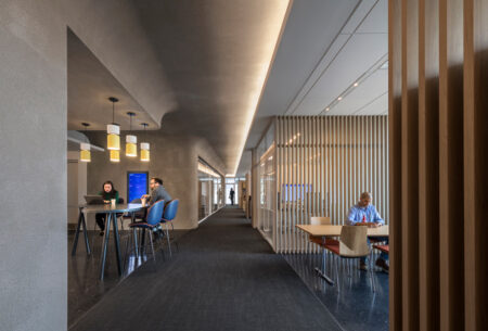 Boies Schiller Flexner open office space bustling with people diligently working at tables, creating a productive and professional atmosphere.