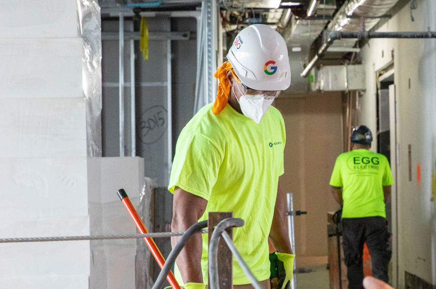 A construction worker wearing a safety helmet and safety glasses while working on a construction site.