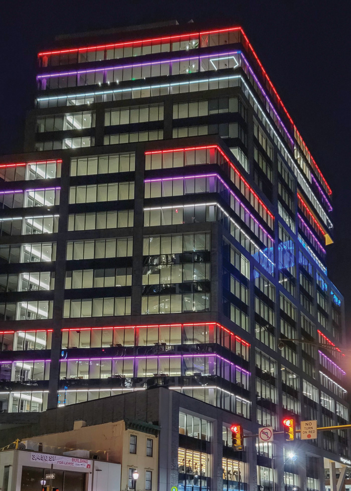 The Morgan Lewis building illuminated with vibrant purple and red lights, creating a captivating and colorful display.