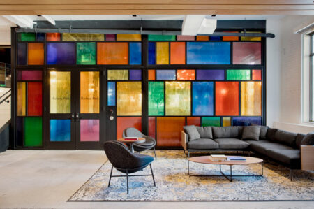 A vibrant office wall adorned with a couch and chairs, creating a lively and inviting atmosphere.