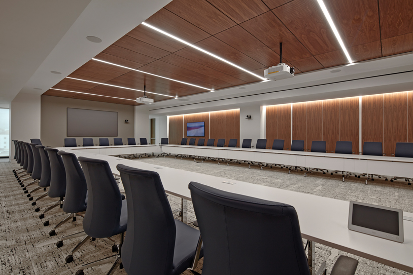 A conference room with a long table and chairs, ready for a meeting.