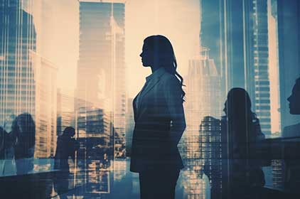 Silhouette of a business women with buildings in the background.