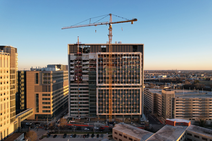 Unfinished Penn Medicine building with scaffolding and construction equipment.