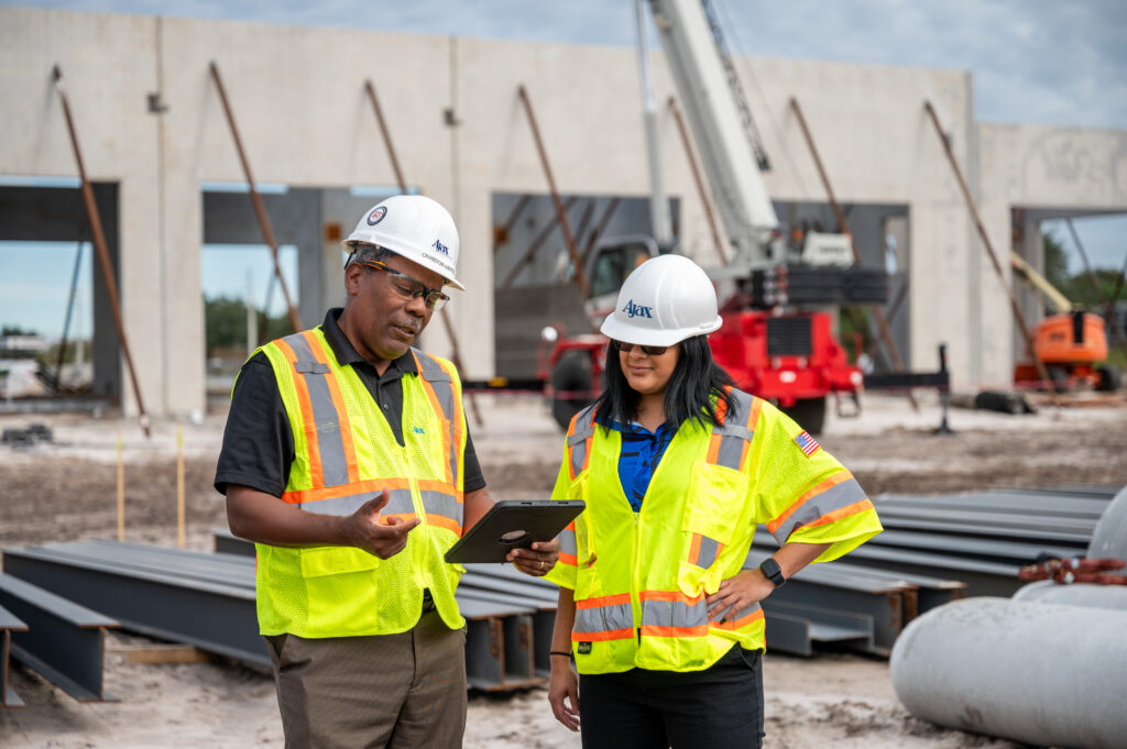 Ajax Building Company employees on a project site wearing personal protective equipment.