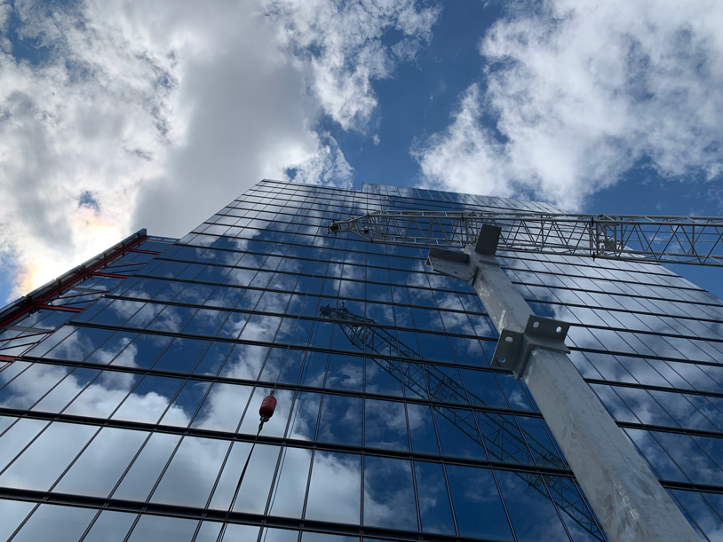 Tall building with all glass windows and a crane