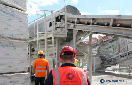 Construction workers wearing PPE doing a site tour.