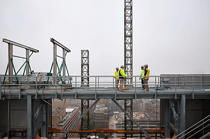 Construction workers wearing full PPE on top of a bridge