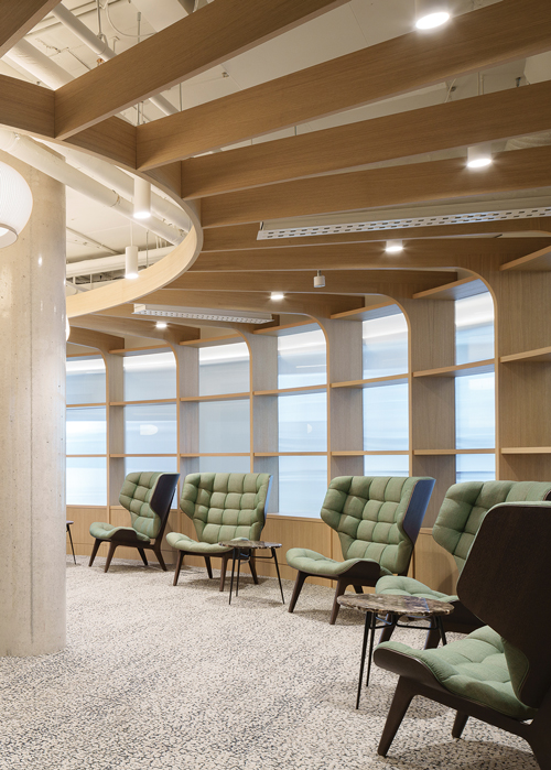 Green chairs lined up along the windows providing ample seating.