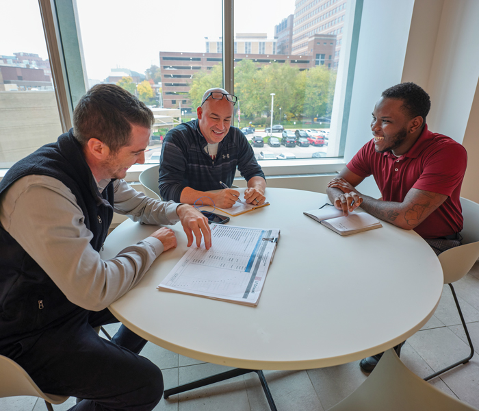 Three men discussing at a table.