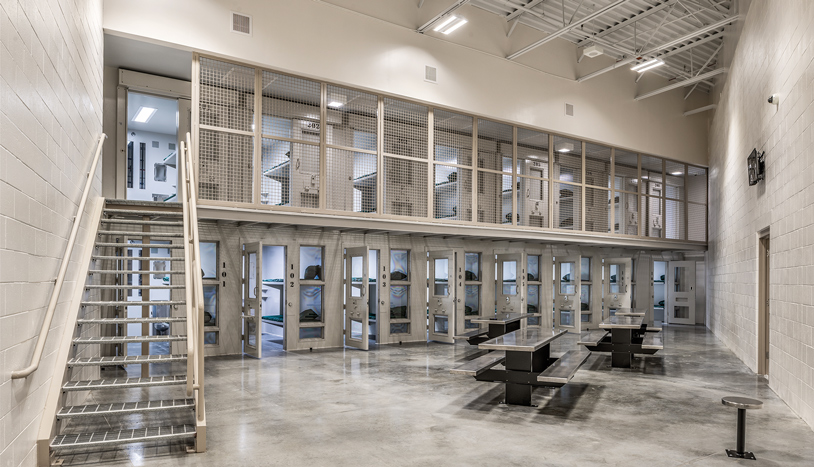 Jail cells and open area with tables