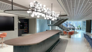 Corporate interior of a law firm with a large center island and feature chandelier hanging above.