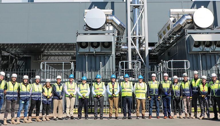 row of construction workers in safty gear in from of a building at Structure Tone mission Critical Amsterdam