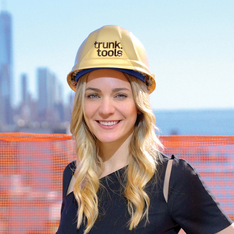 sarah buchner CEO, Trunk Tools wearing a yellow hard hat at a job site backdrop