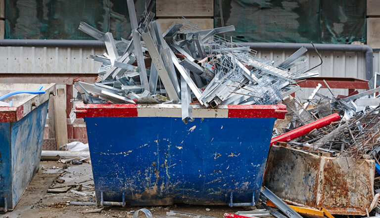 blue dumpster with metal in it