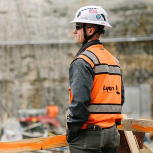 A construction worker in safety gear looking out at a jobsite