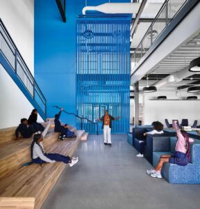 Interior of an education center with students listening to their teacher.