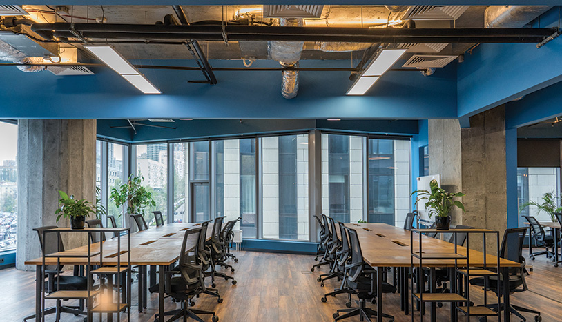 Construction Cost Report – STOBG Global Services March 2026 An office area with long tables and chairs for employees to use.