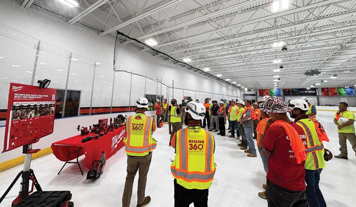 A group of construction workers listening to a safety demonstration on the project site.