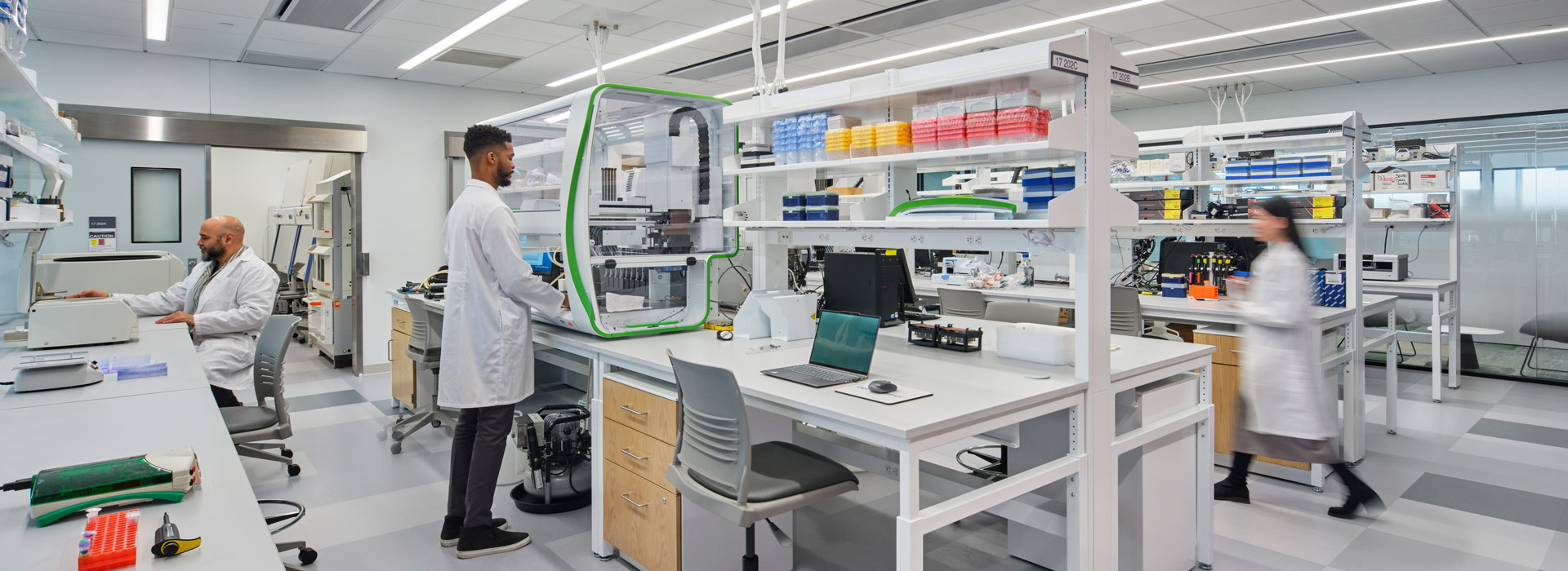 An image of a lab with three lab scientists working