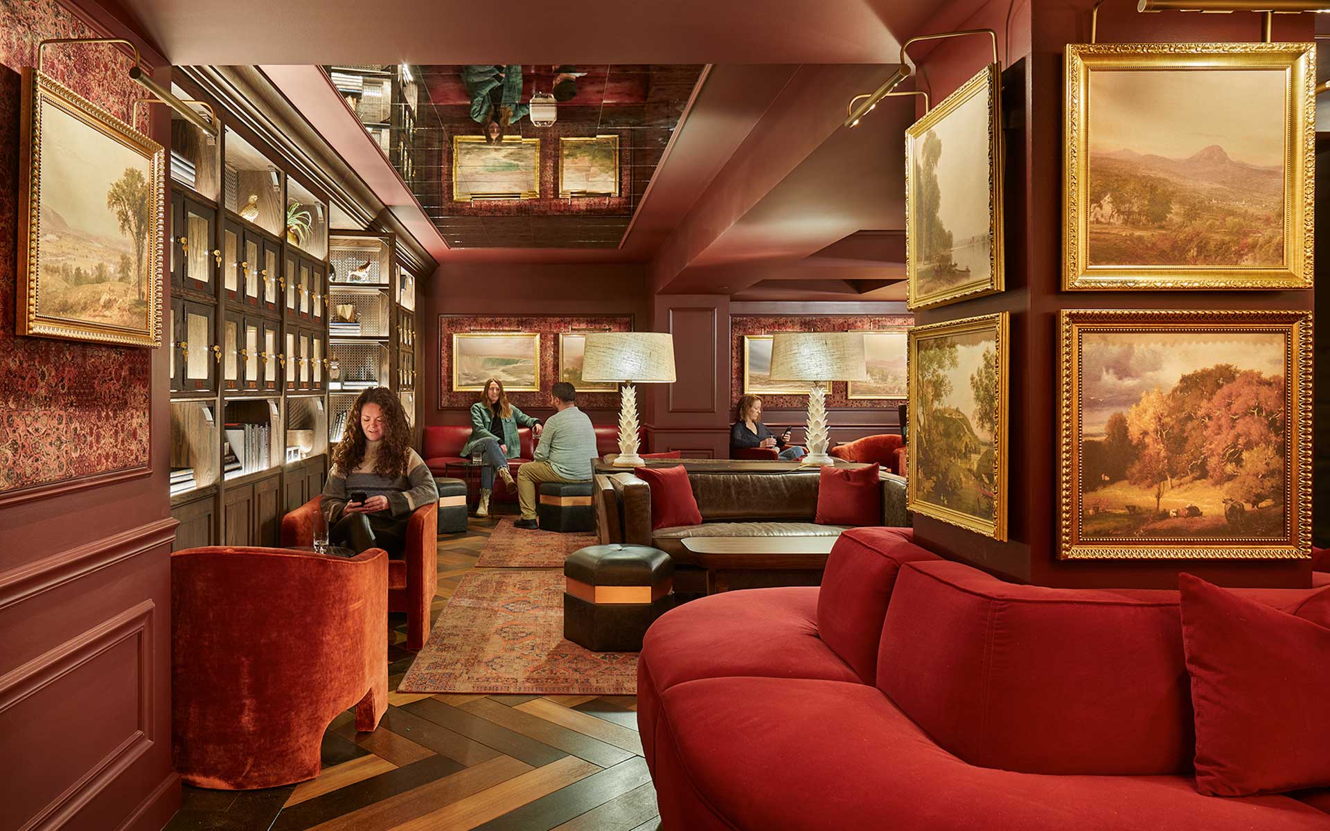 Lounge area with decorative frames and red sofa's.