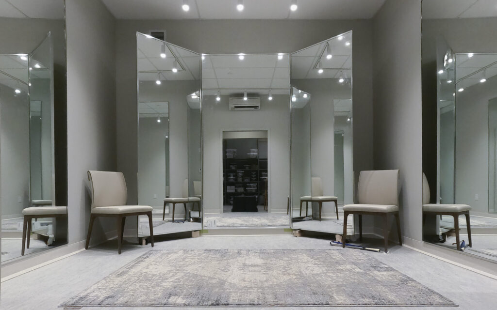 A big room including multiple mirrors and chairs for lounging.