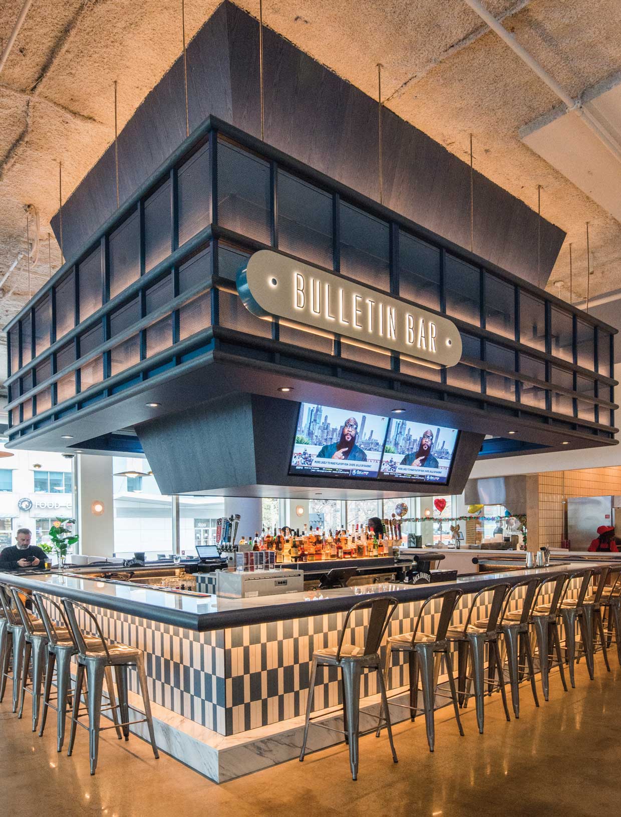 Bar with high-top chairs and tv's