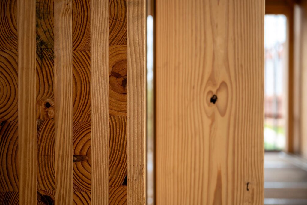 Close-up of exposed mass-timber columns and beams, highlighting the wood’s layered construction and natural grain.