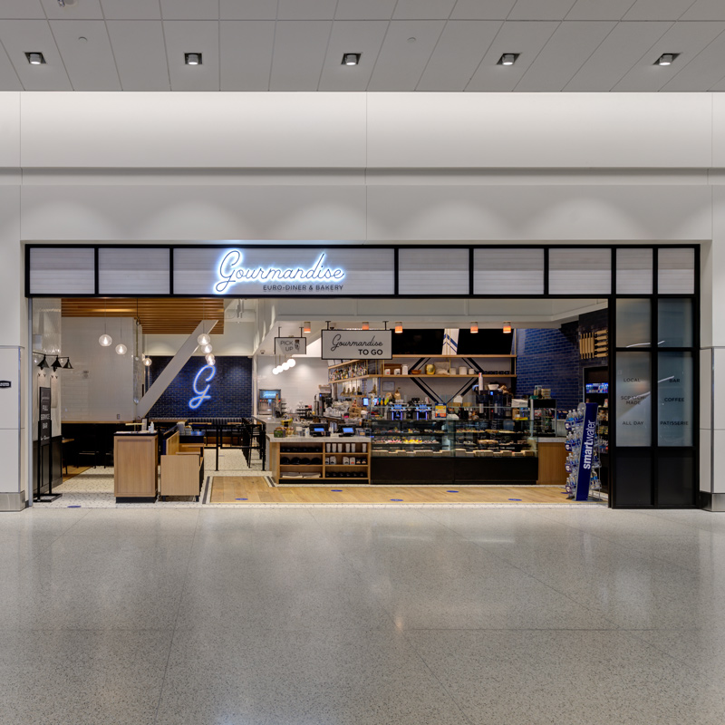 Gourmandise Euro-Diner & Bakery storefront inside Salt Lake City International Airport, featuring an open counter, display cases, and seating.